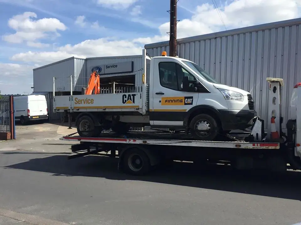 Plant service truck with a mounted crane loaded on a Simpsons flatbed recovery truck